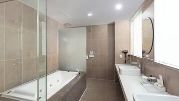 A modern bathroom with a glass-enclosed shower, a freestanding bathtub, and a double sink vanity.