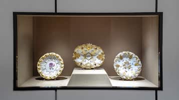 Three ornate plates displayed in a glass case.