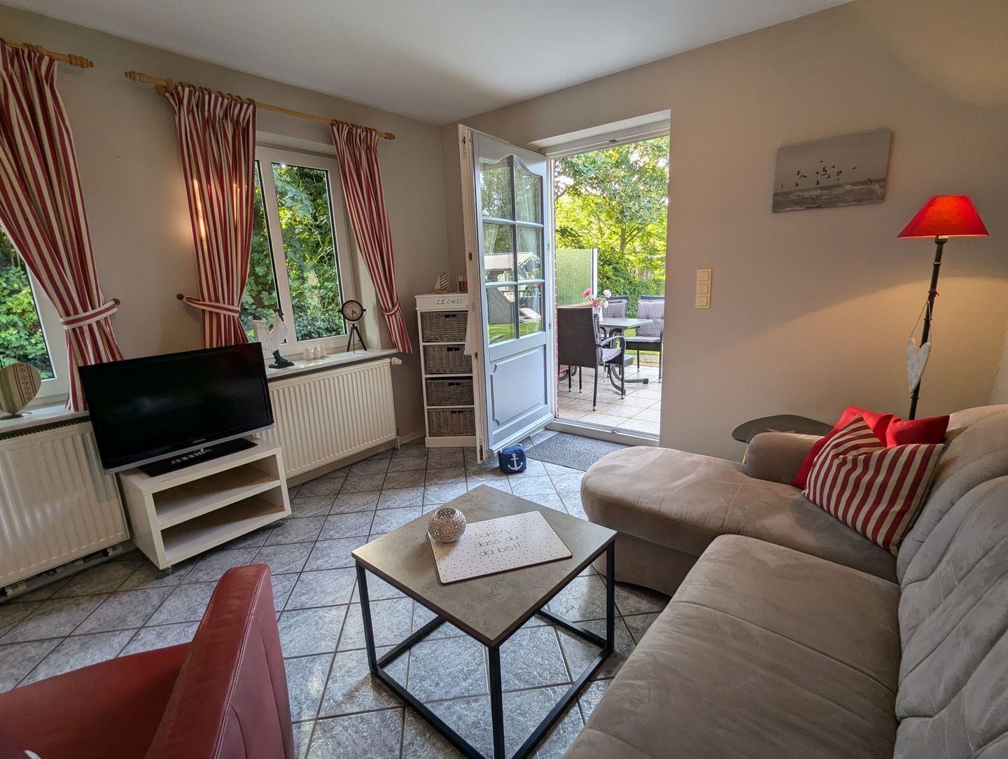 Un salon équipé d’un téléviseur, d’un canapé, d’une table basse et offrant une vue sur l’extérieur.