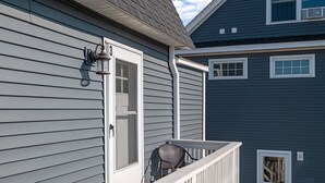 A house with a balcony, a door, and a window. - Steps to Hampton Beach and all entertainment! 4 bedrooms, pet friendly! (Hampton)