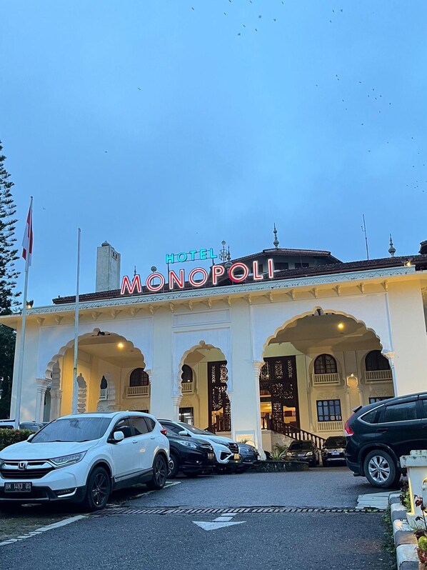 A hotel named "HOTEL MONOPOLI" with a traditional architectural style, featuring arched entrances and a prominent sign. - Monopoli Hotel Bukittinggi (Bukittinggi)