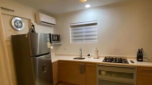 Una cocina moderna con refrigerador, microondas, estufa y pileta.