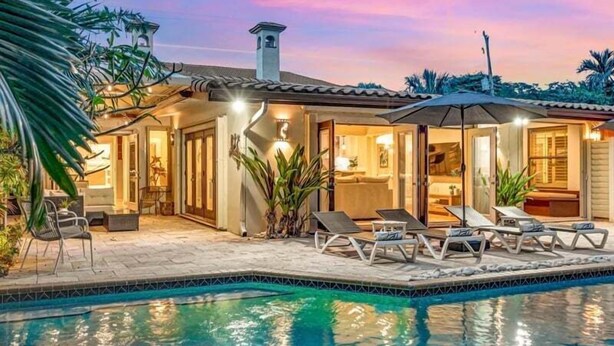 A poolside area with lounge chairs, a covered patio, and a pool. - Heated pool / Quiet Neighborhood / Family Vacation / Escape Key (Fort Lauderdale)