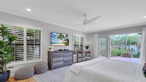 A bedroom with a bed, a dresser, a desk, and a large window with blinds. - Heated pool / Quiet Neighborhood / Family Vacation / Escape Key (Fort Lauderdale)