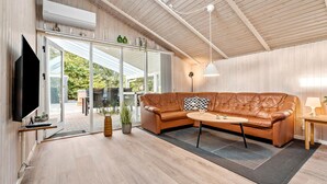 Un salon moderne avec un canapé en cuir, une table basse et un téléviseur.
