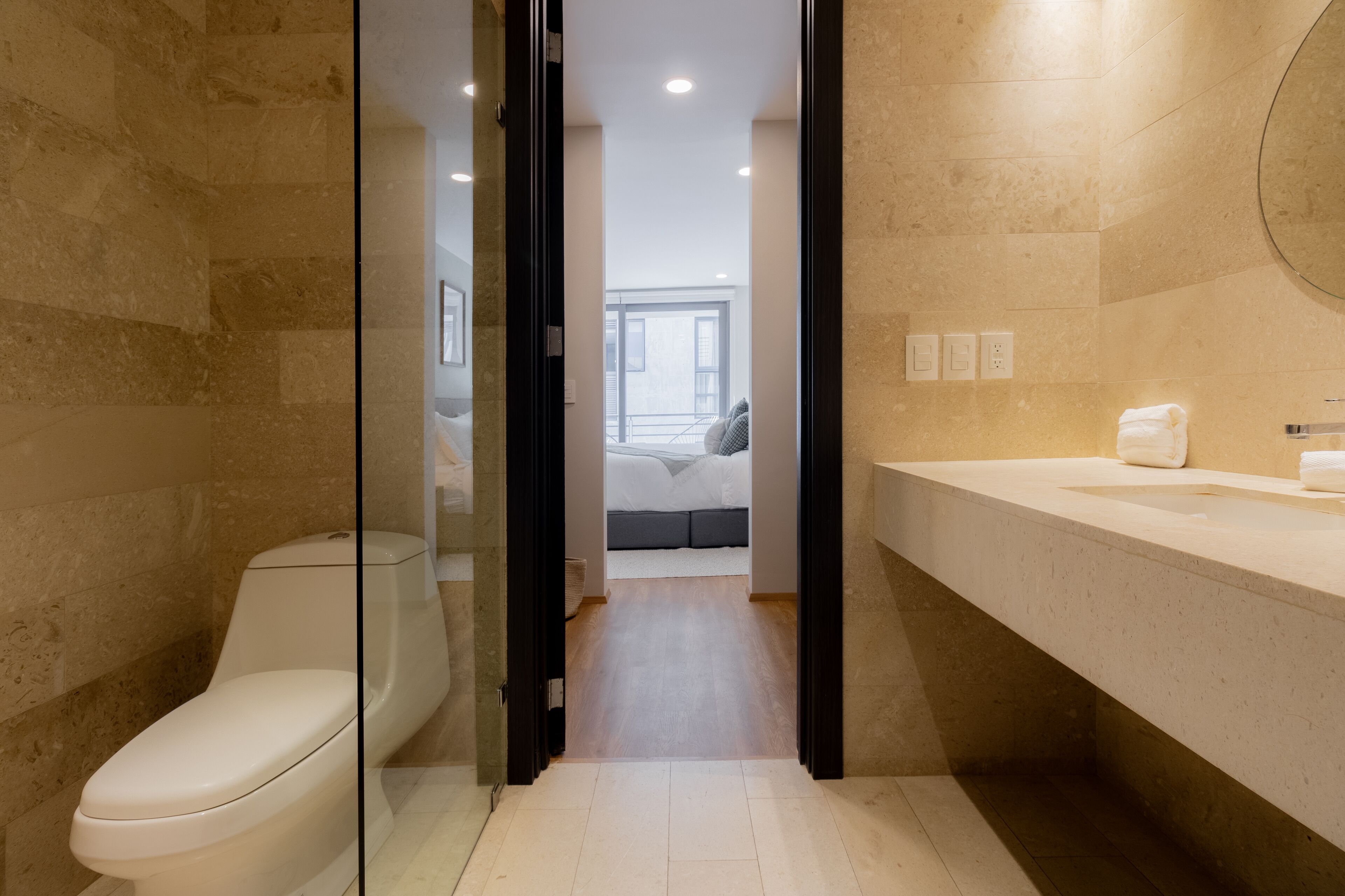 A modern bathroom with a toilet, a sink, and a shower area.