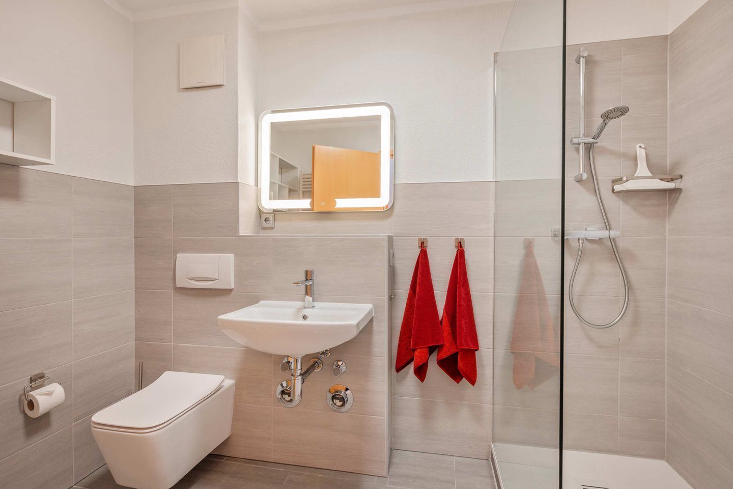 A modern bathroom with a toilet, sink, and shower.