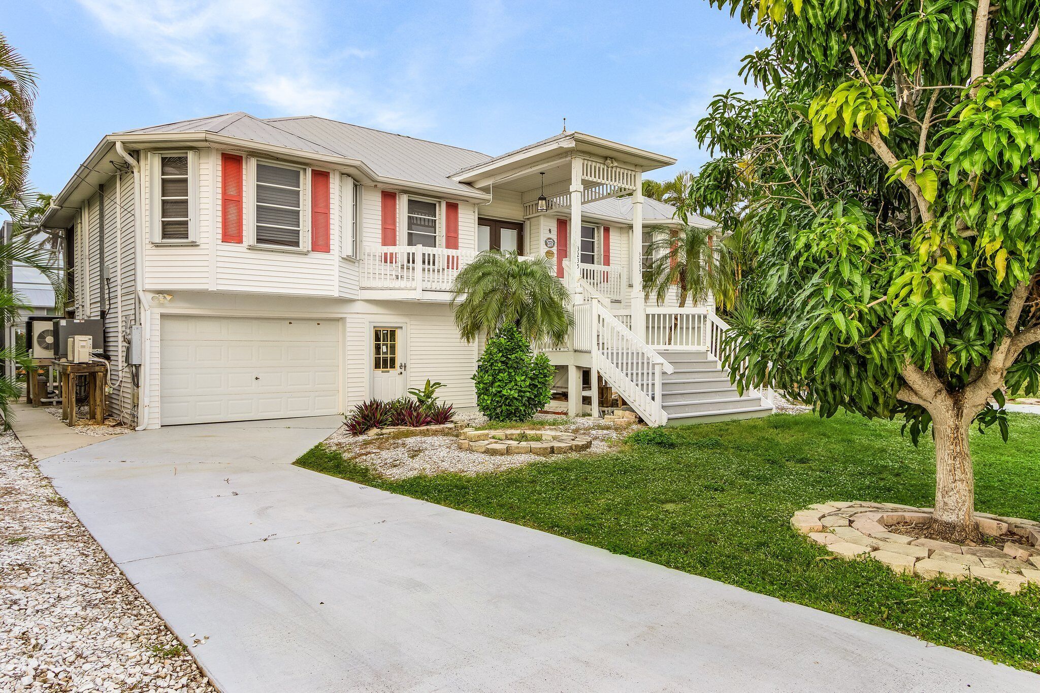 A two-story house with a white exterior, red shutters, and a covered front porch.
