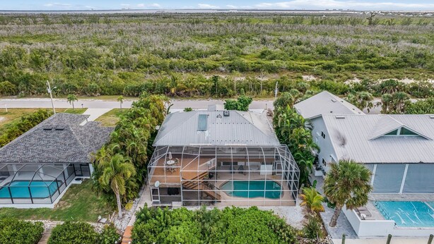 A modern house with a large deck, a swimming pool, and a view of a natural landscape. - 3/2 Pool Home in St. James, Gorgeous Views! (Saint James City)