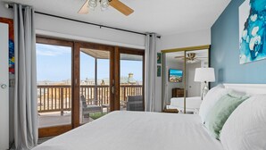 A hotel room with a large bed, a balcony with a view, and a ceiling fan. - La Mirage Condo 305 Beachfront Resort Condominiums with Private Boardwalk (Port Aransas)