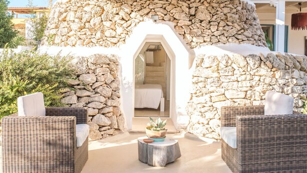 A stone-walled structure with a doorway leading to a bedroom. There are wicker chairs and a small table with a plant in the foreground. - Wonderful private villa for 6 guests with private pool, A/C, WIFI, TV and terrace (Torricella)