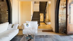 Ein modernes Wohnzimmer mit einer Couch, einem Glastisch und einer Treppe zu einer oberen Etage.