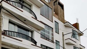 A multi-story hotel with balconies and large windows. - HOTEL LOS ANGELES (Huaral)