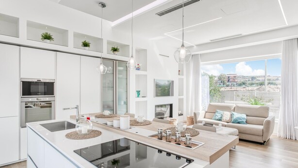 A modern kitchen with a central island, built-in appliances, and a view to the outdoors.