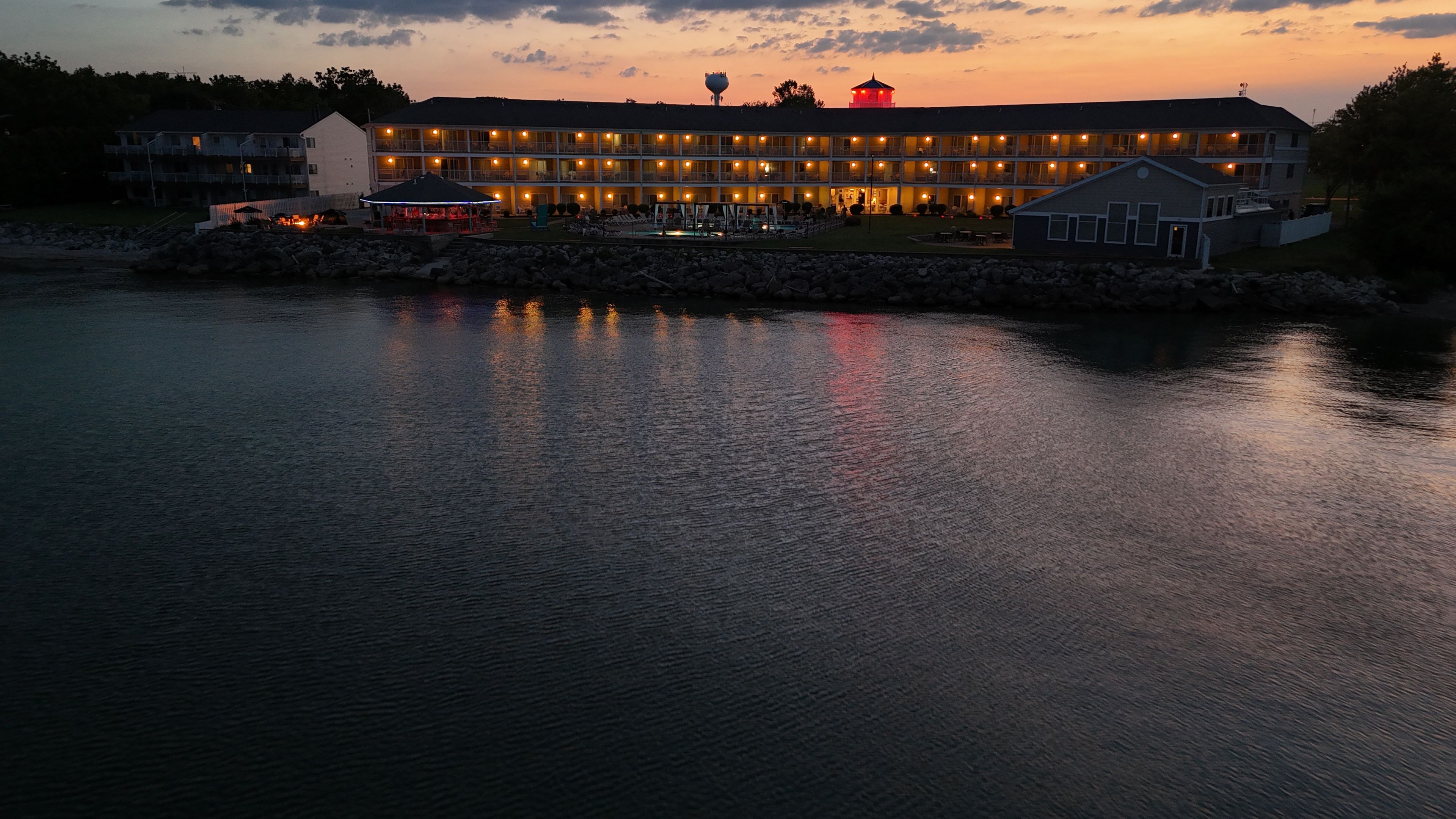 Ein Hotel am Wasser mit mehreren Balkonen und einem Poolbereich.