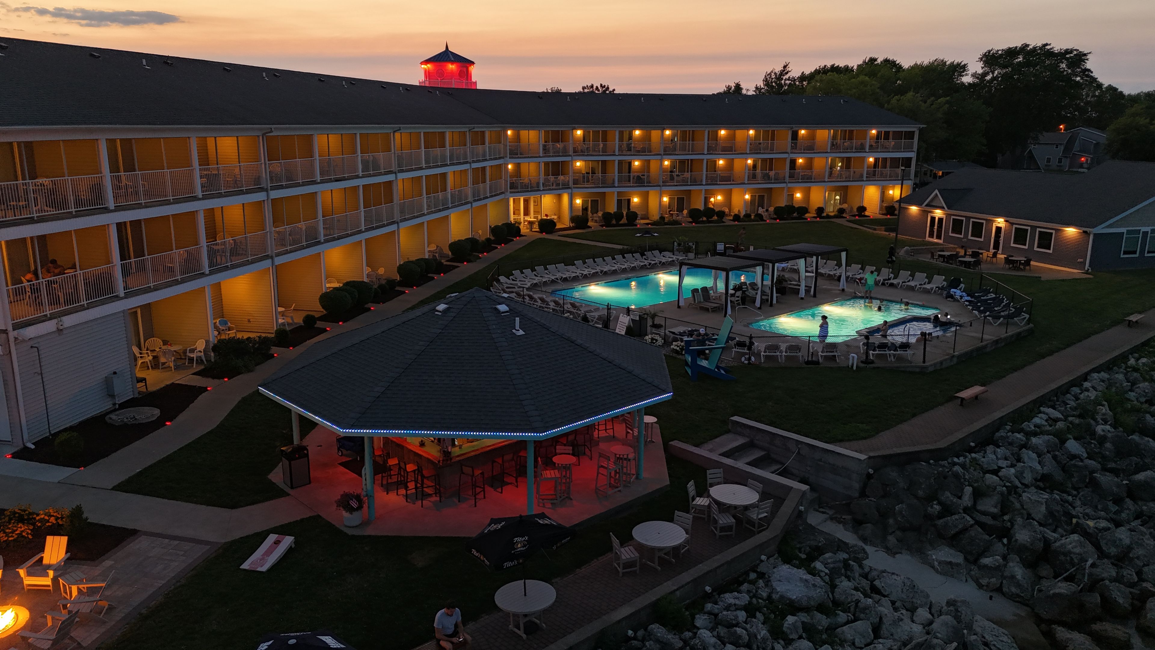 Ein Hotel mit Poolbereich, Sitzgelegenheiten im Freien und einer überdachten Terrasse.