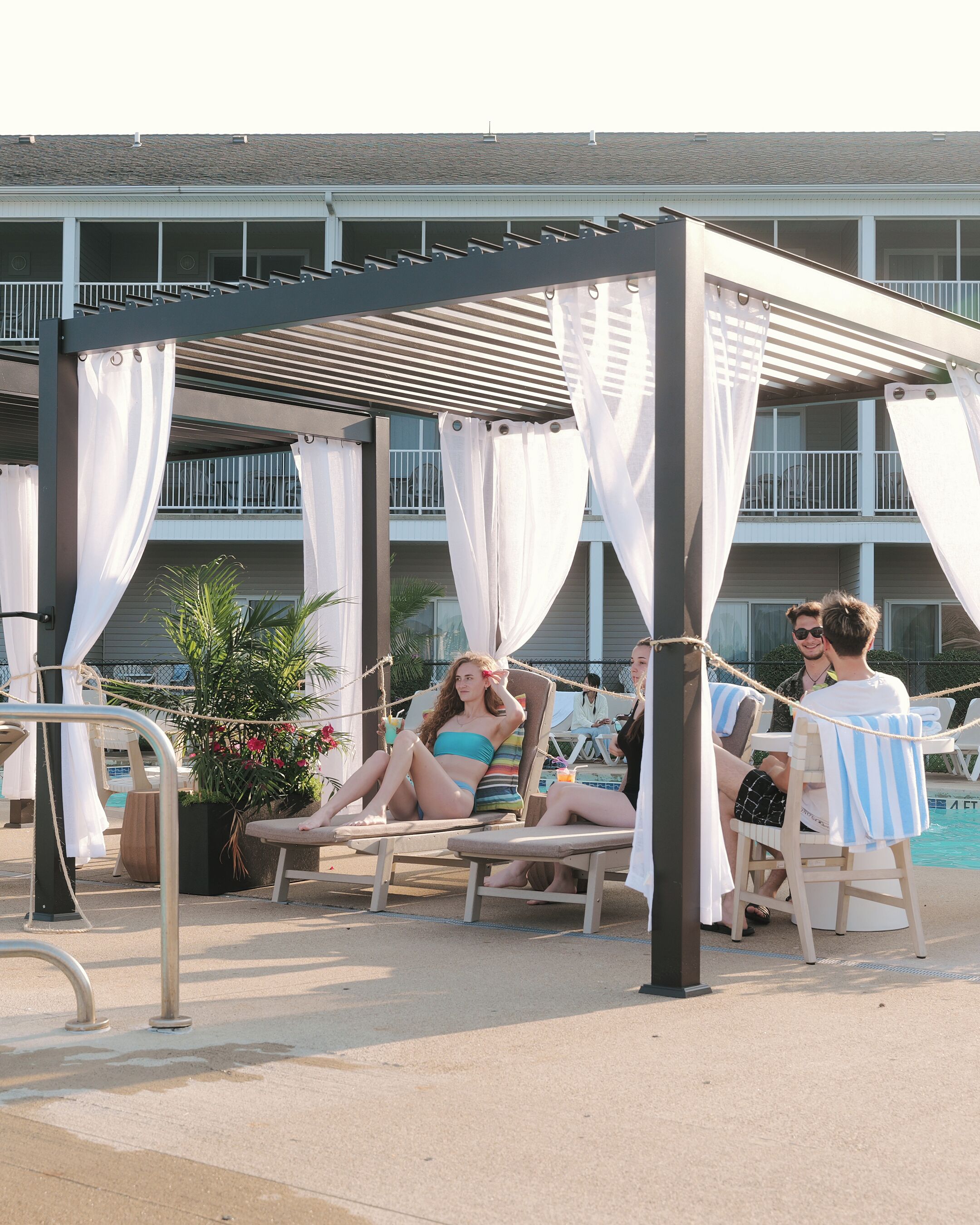 A poolside area with lounge chairs and a canopy structure.