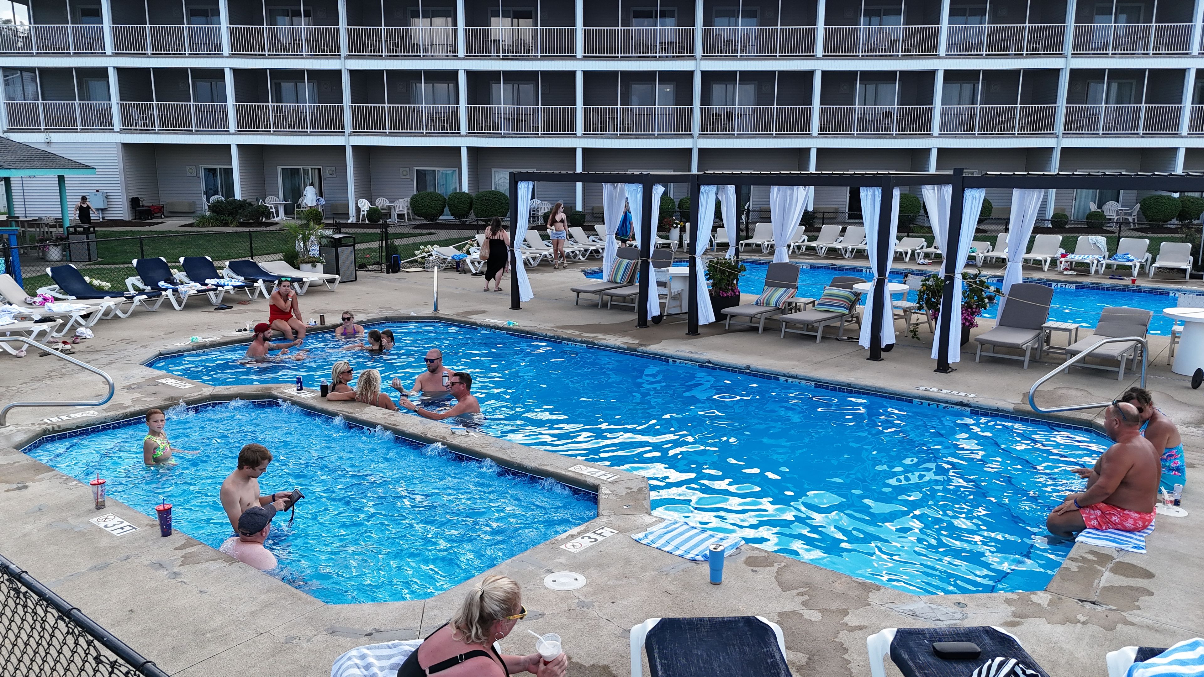 A pool area with multiple pools, lounge chairs, and umbrellas.