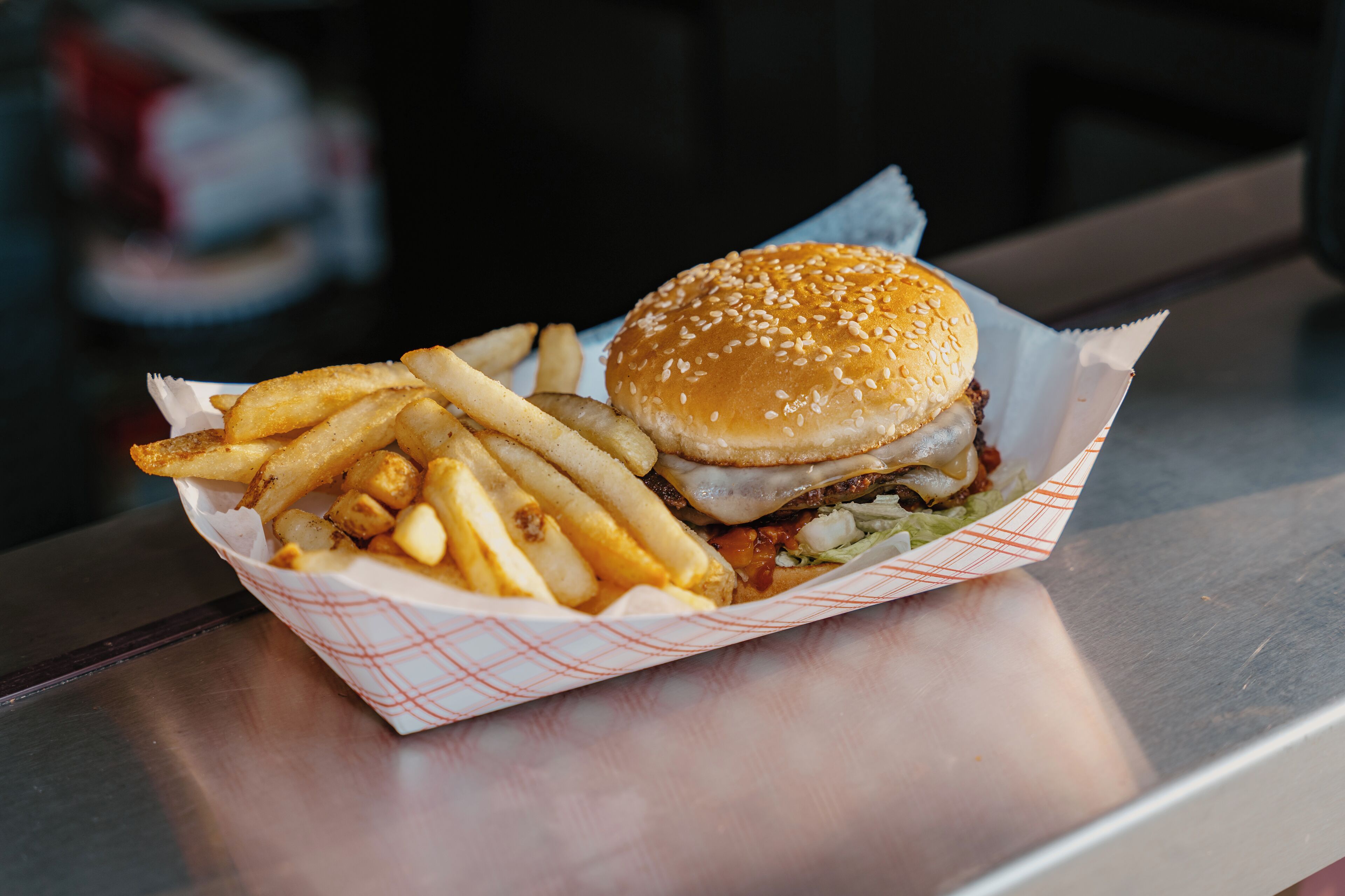 A burger and fries in a paper container.