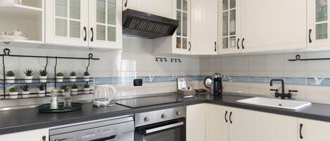 Een koelkast, een broodrooster, kookgerei, borden en bestek