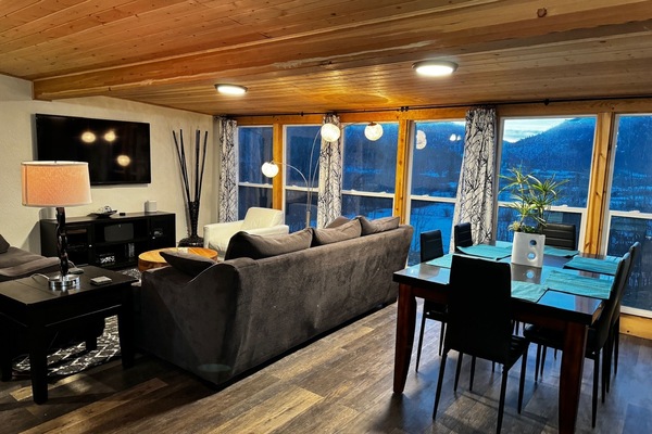 Living room with dining table behind couches and the mountain view.