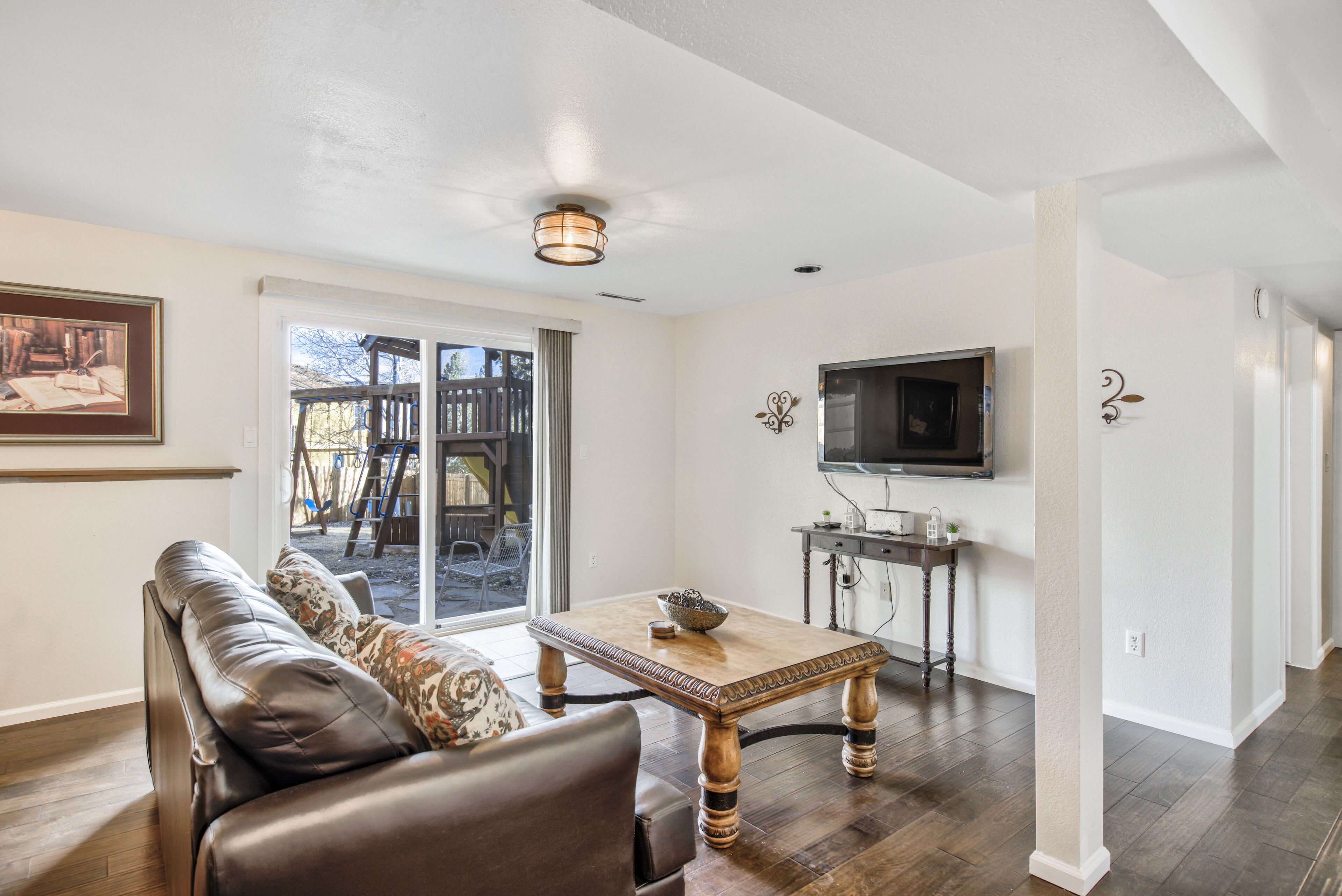 A living room with a sofa, a coffee table, and a television.