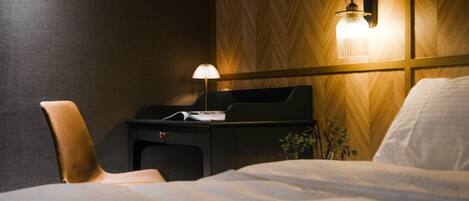 Une chambre d’hôtel avec un lit, un bureau doté d’une lampe et une chaise.