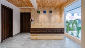 Un mostrador de recepción con detalles de madera y un letrero que dice "TEA HARBOUR".