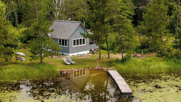A house surrounded by a pond with a wooden dock.