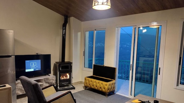 A living room with a TV, a fireplace, a sofa, and a coffee table.