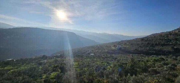 Un paisaje montañoso con cielo despejado y luz solar.