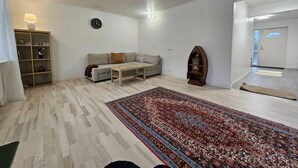 A living room with a sofa, coffee table, and a patterned rug.