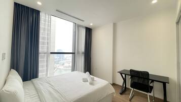 A hotel room with a bed, a desk, and a chair.