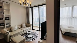 A modern living room with a sofa, ottoman, and a round black and white patterned rug.