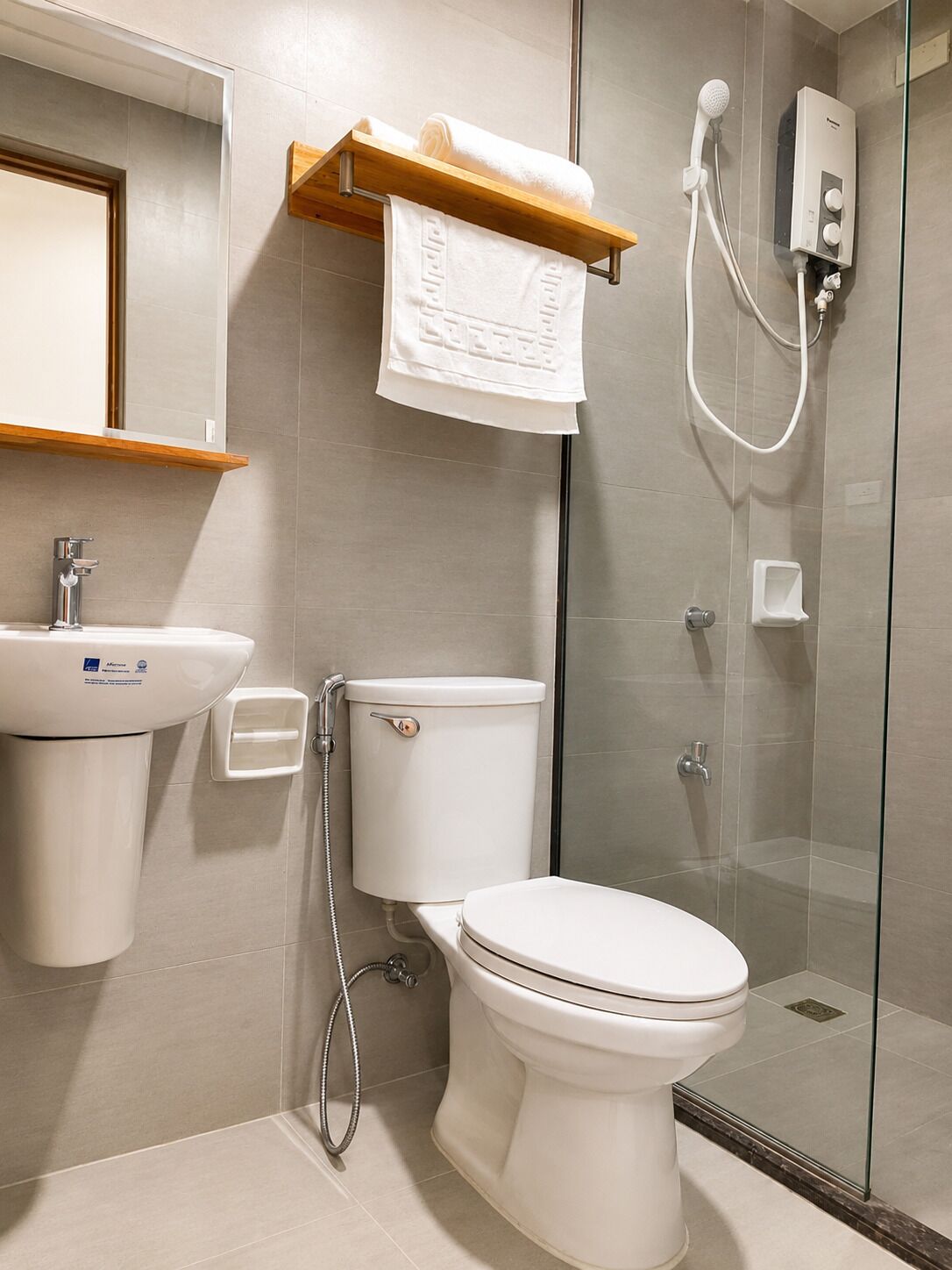 Une salle de bain moderne équipée de toilettes, d’un lavabo et d’une douche.