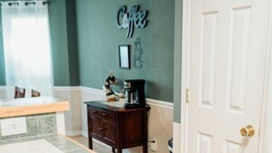 Una cocina con un armario de madera, una puerta blanca y una pared con un letrero que dice 'Coffee'.