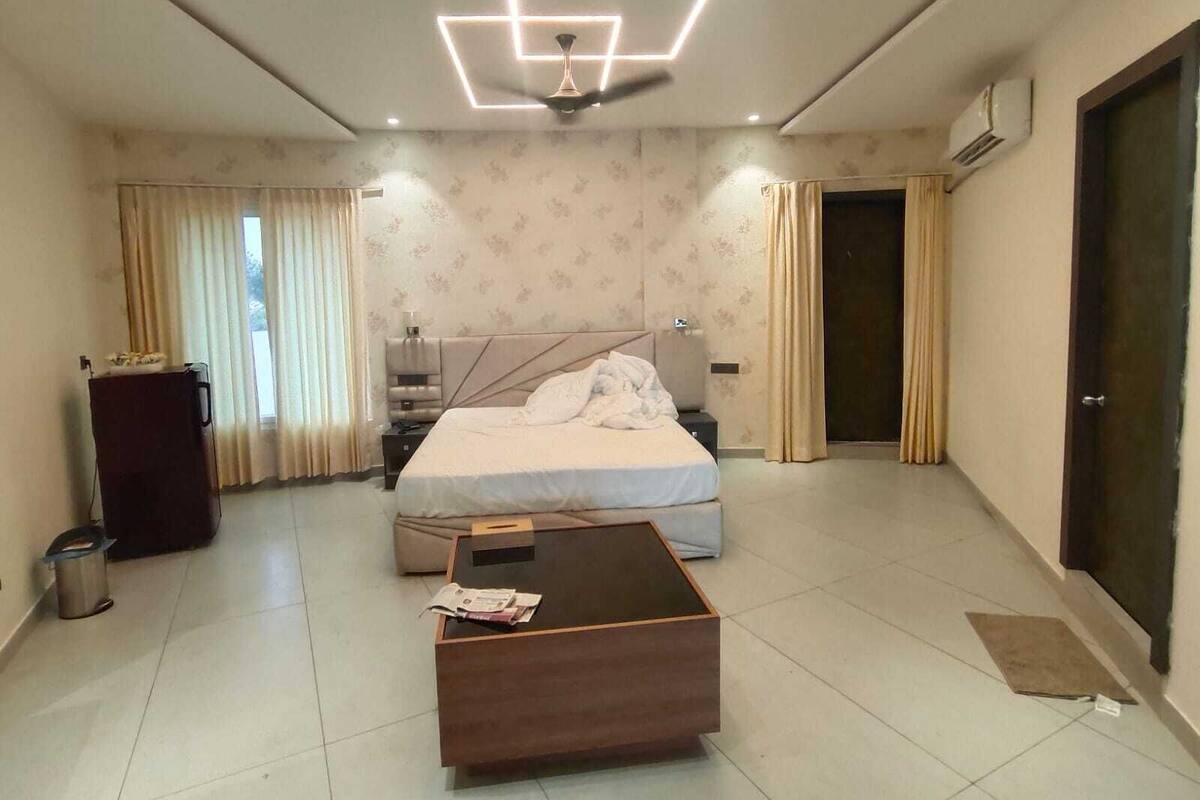 Una habitación de hotel con cama, escritorio, ventilador de techo y puerta.