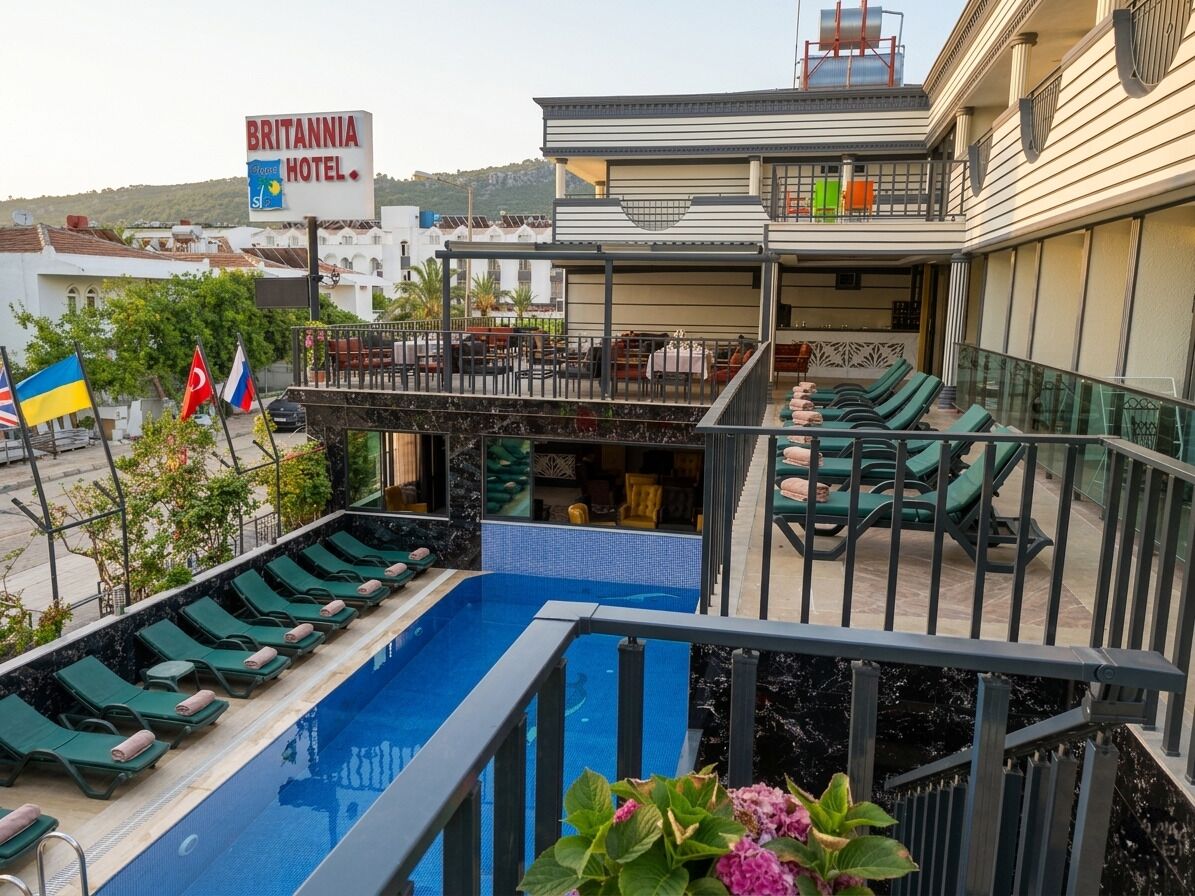 A hotel with a pool, outdoor seating, and a balcony.