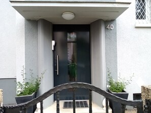 A building entrance with a number '40' on the wall, a door, and a small window with a metal grill. - Holiday flat B 40 / Wasgaublick (Pirmasens)