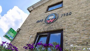 A brick building with a circular logo and the year 1950. - Apartment 'Devich' with Private Terrace, Private Garden and Wi-Fi (Oersberg)