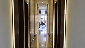 Corredor de hotel com portas numeradas 116, dando acesso aos quartos.