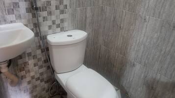 A bathroom with a toilet, a sink, and a shower.