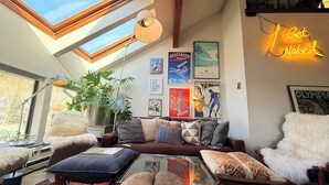 Una sala de estar acogedora con sofá, sillones, una mesa de centro y un tragaluz.
