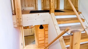 Eine Holztreppe führt zu einem Schlafbereich mit einer Galerieebene.