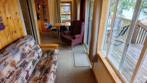 A cozy cabin interior with a sofa, a dining table, and a chair.