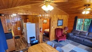 L’intérieur d’une cabane en bois comprend un coin repas, une cuisine et un salon.