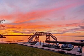 A sunset view at a dock with boats and a wooden staircase structure. - Lakeside 2 Bedroom Pelican Cabin on Kab (Kabetogama)