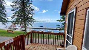 A wooden deck with a view of a lake and dock area.