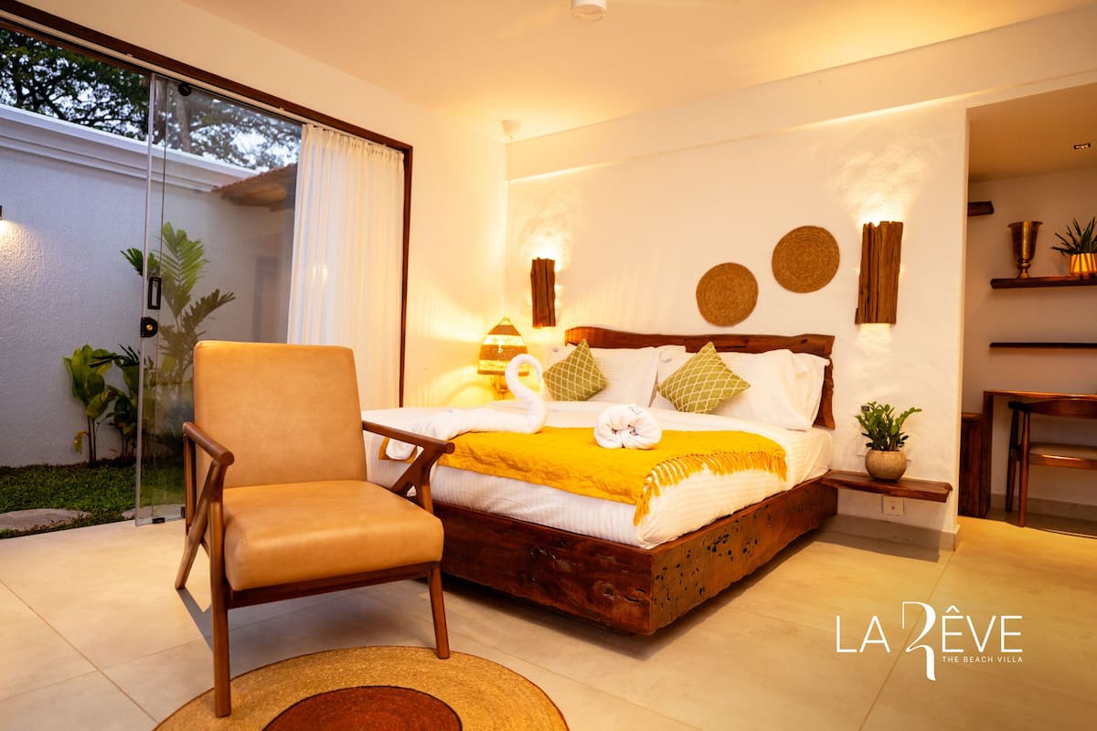 A bedroom with a wooden bed, a chair, and a small table.