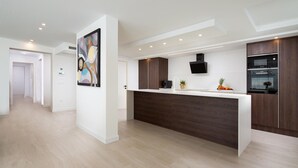 Una cocina moderna con una isla de madera, horno empotrado y cafetera.